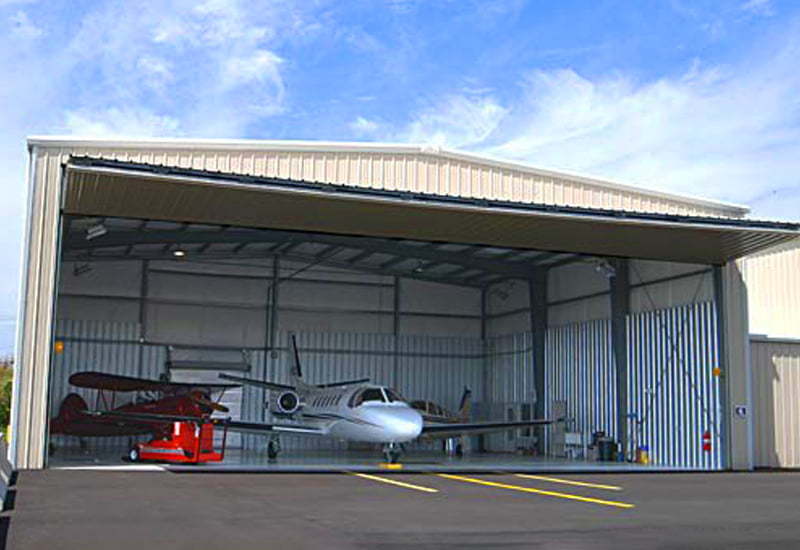 Exterior image of an open prefab steel airplane hangar