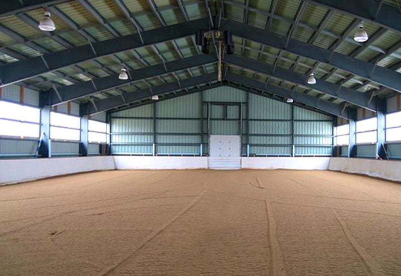 Interior of a prefab steel riding sporting arena with translucent panels and steel rigid frames